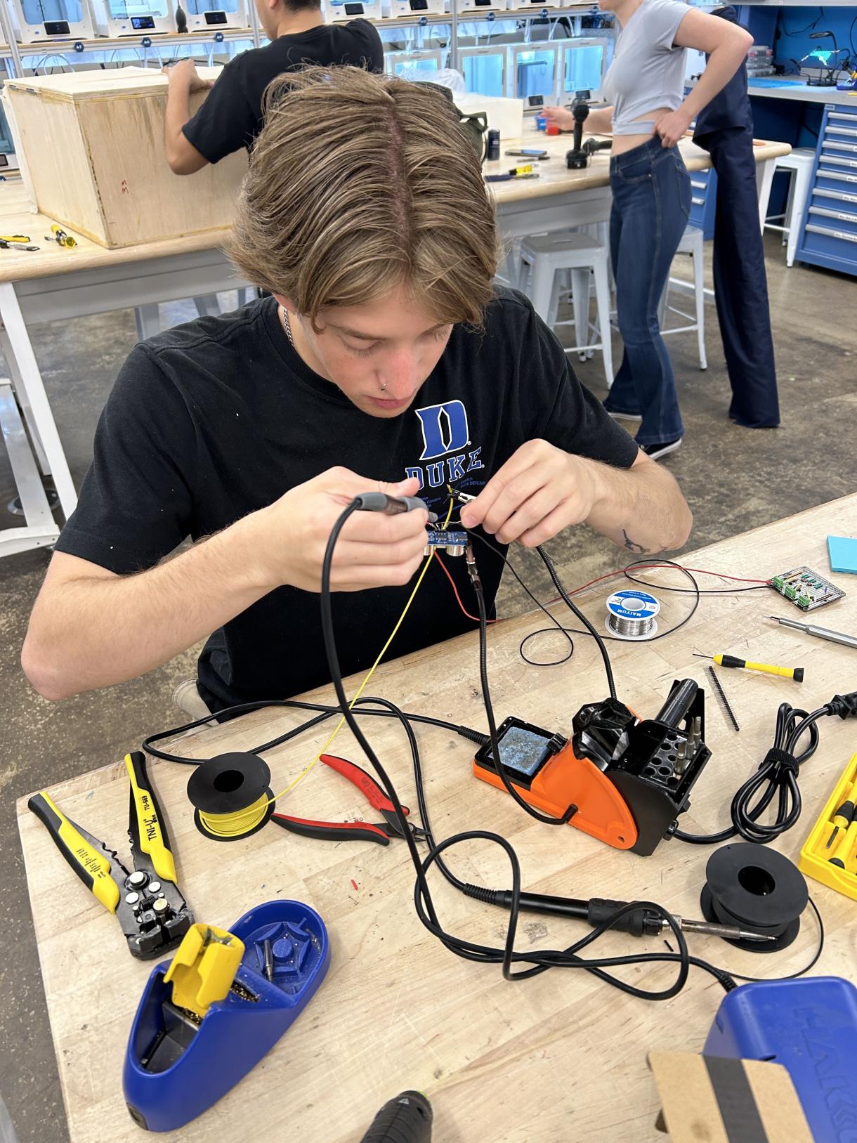student soldering parts together for a project