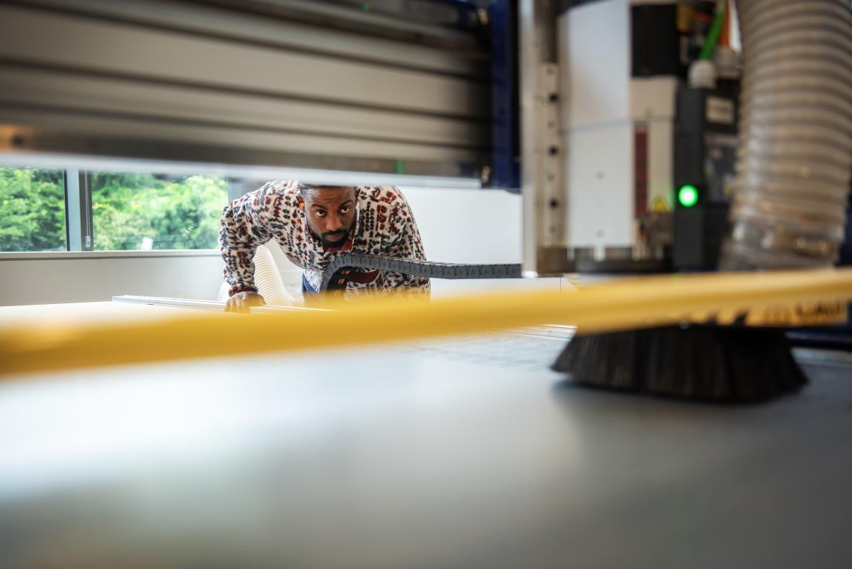 Roland looks while operating the CNC machine at the Co-Lab